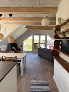 a dining room and living room with a table at Nordgården - ferie på landet in Skibby