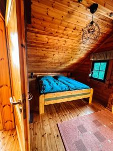 ein Zimmer mit einem Bett in einer Holzhütte in der Unterkunft Blockhaus Rügen - Natur, Strand und Mee(h)r in Dranske + 14 Fotos