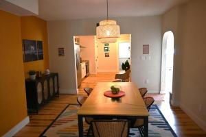 a dining room with a wooden table and a dining roomiasm at Bridge City Row House in Pittsburgh