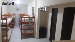 a room with several bunk beds in a dorm room at Flamboyant hostel in Cabo Frio