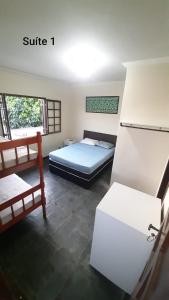 a bedroom with a bed and a refrigerator in it at Flamboyant hostel in Cabo Frio