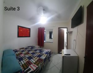 a small bedroom with a bed and a television at Flamboyant hostel in Cabo Frio