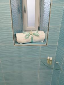 specchio in bagno con asciugamano e fiocco di SoleMare Rooms "Acquamarina" a Procida