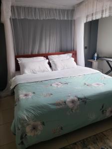 - un lit avec une couverture bleue et des fleurs dans l'établissement Buildnet 59 Najjera 1, à Kampala