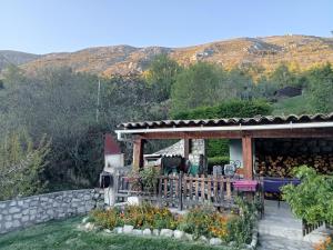 ein Haus mit einer Terrasse und Blumen im Hof in der Unterkunft AlpesAzur in Coursegoules