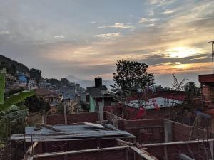 a view of a city with the sunset in the background at Sunrise View Homestay in Tānsing