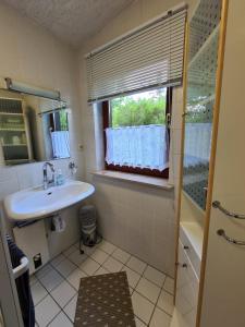 a bathroom with a sink and a window at Gemütliches Ferienhaus mit Kamin in idyllischer Waldrandlage 