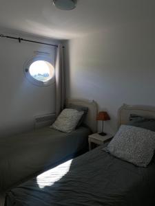 1 Schlafzimmer mit 2 Betten und einem Fenster in der Unterkunft Au pied des Alpilles in Paradou