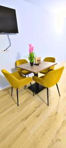 einen Esstisch mit gelben Stühlen und einem Tisch in der Unterkunft Vacansis Apartamentos Bulevar in Valencia