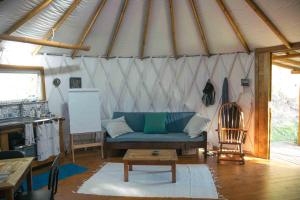 uma sala de estar com um sofá azul numa tenda em Comunidade Ibipuris em Nova Friburgo