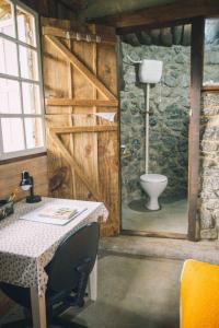 um quarto com uma casa de banho com um WC e uma mesa em Comunidade Ibipuris em Nova Friburgo