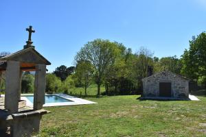a small chapel and a cross next to a pool at Cabana de Pili in A Estrada