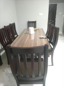 una mesa de madera con 4 sillas y una taza. en Ana Rooms, en Tema