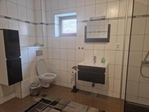 a bathroom with a toilet and a sink at CASA ANA Apartament 1 in Câmpulung Moldovenesc +5 photos