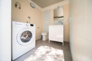 eine Waschküche mit einer Waschmaschine und einem WC in der Unterkunft A un passo dal Mare - Villa Corallo Torre Borraco in Manduria