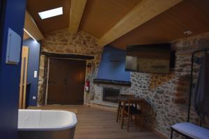 a living room with a stone fireplace and a tv at Cabana de Pili in A Estrada