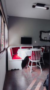 uma sala de estar com um sofá, uma mesa e 2 cadeiras em CURTA! | Casa dos Pássaros - Campo Alegre em Campo Alegre