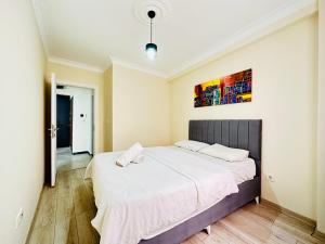 1 dormitorio con 1 cama grande con sábanas blancas en Modern Cozy Apt For Large Group and Families, en Estambul