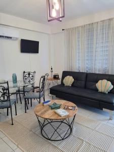 薩利納斯的住宿－Marina Bliss Apartment，客厅配有黑色沙发和桌子