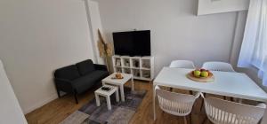 a living room with a table and chairs and a television at Charmers SM in Zagreb