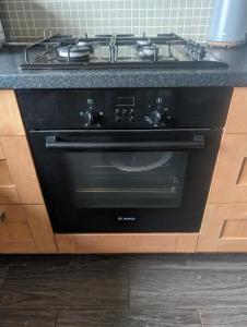 a black stove top oven in a kitchen at Budget rooms in Dudley in Tipton