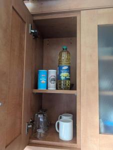 a cupboard with a large bottle of water and cups at Budget rooms in Dudley in Tipton