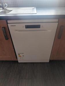 a white dishwasher under a counter in a kitchen at Budget rooms in Dudley in Tipton