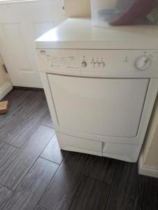a white dishwasher in a kitchen with a wooden floor at Budget rooms in Dudley in Tipton
