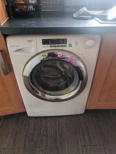 a washing machine in a kitchen with its door open at Budget rooms in Dudley in Tipton