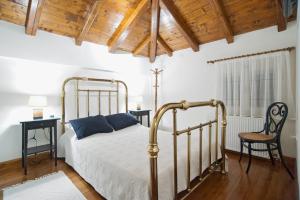 特尔斐Cozy Attic Suite - Elia Apartments Chrisso的带床和木质天花板的卧室