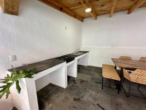 een keuken met een aanrecht en een tafel en stoelen bij Quinta del Valle Suite Jr 3 2pax in Valle de Bravo
