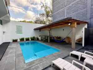 een zwembad met een hangmat naast een gebouw bij Quinta del Valle Suite Jr 3 2pax in Valle de Bravo