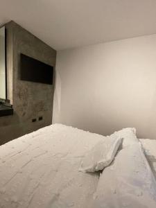 a white bed in a room with a wall at Casa Valentina Habitación 5 in Aguascalientes