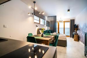 a dining room and living room with a table and chairs at Apartamenty Enklawa pod Giewontem by Apart Concept Podhale in Kościelisko