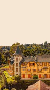 un grand bâtiment avec une tour en haut dans l'établissement Hotel Le Renard - Campos do Jordao, à Campos do Jordão