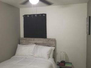 een slaapkamer met een bed met een houten hoofdeinde bij 3BR 2 And A Half BA Cozy Quiet Home Away From Home in Port Arthur