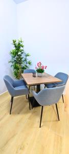 Vacansis Apartamentos Bulevar في فالنسيا: طاولة خشبية وكراسي زرقاء وطاولة بها ورد