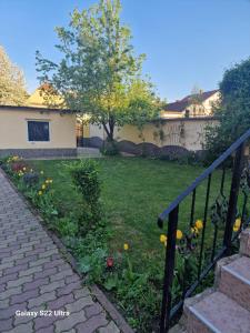 a house with a yard with a garden with flowers at Apartament Teilor in Râşnov