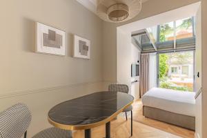 sypialnia ze stołem, łóżkiem i oknem w obiekcie Maison du Moulin Vert w Paryżu