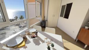 a white dining room with a view of the ocean at Madrid-M504 in Torrox Costa