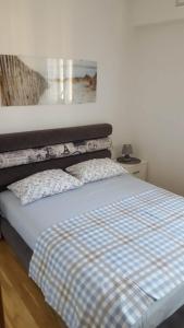 een slaapkamer met een bed met een geruite deken bij Holiday Apartment in Budva