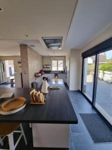 a living room with a dining table and a kitchen at Le Coin Cosy in Saint-Valery-sur-Somme
