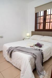 een slaapkamer met een groot wit bed met bloemen erop bij Apartamento BOREAS PARADISE Costa del Silencio in Costa Del Silencio