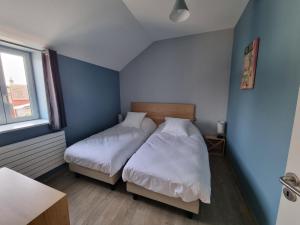 two beds in a room with blue walls at Le Coin Cosy in Saint-Valery-sur-Somme