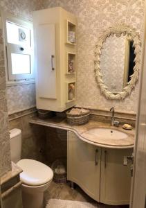 a bathroom with a sink and a toilet and a mirror at فيلا بالكامل الساحل مارينا اطلاله فيو البحر in El Alamein