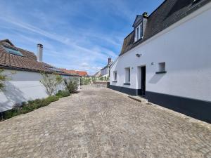 an empty road between two white buildings at Le Coin Cosy in Saint-Valery-sur-Somme