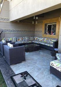 a patio with couches and a table and a window at فيلا بالكامل الساحل مارينا اطلاله فيو البحر in El Alamein