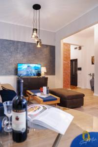 una sala de estar con una botella de vino en una mesa en Saint Moor Suite #1, en Pécs