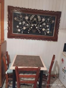 uma mesa com duas cadeiras e uma foto na parede em Erini Room em Kissamos
