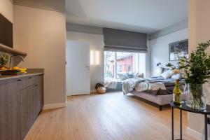 a kitchen and living room with a bed in a room at Monciak Elegance - Plaża in Sopot +4 photos